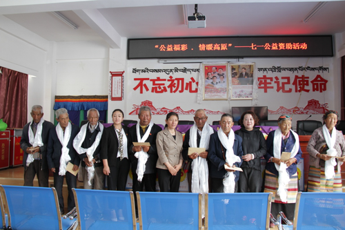 西藏自治区民政厅副巡视员达娃卓玛同志（中）、西藏福彩中心主任唐慧同志（右三）与老党员合影