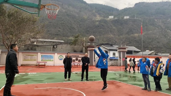 同学们在老师指导下投篮