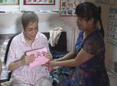 亲手将慰问金送到患者手上