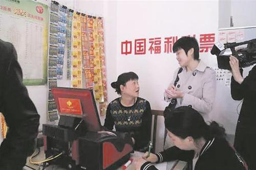 销售员一边打票,一边接受媒体采访 销售员一边打票,一边接受媒体采访
