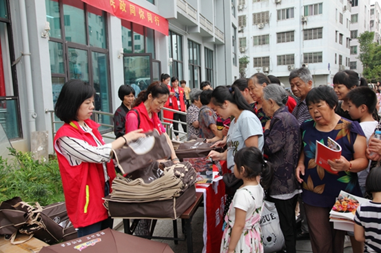 福彩志愿者们向群众免费分发环保袋，雨伞，宣传册