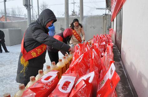 雪中为百位65岁老人送米油