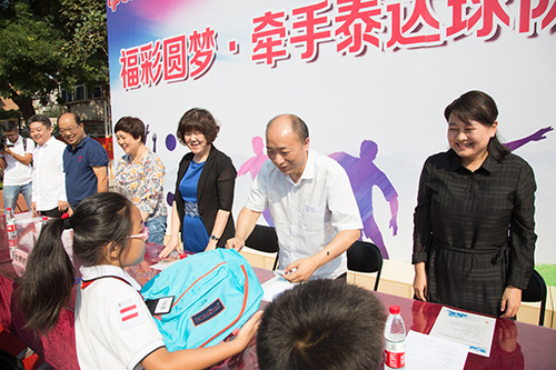 民政局工作人员为孩子们送上福彩书包