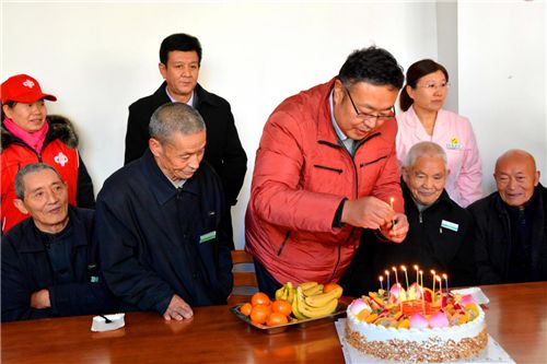 12位老人围坐在福彩工作人员为他们准备的蛋糕前
