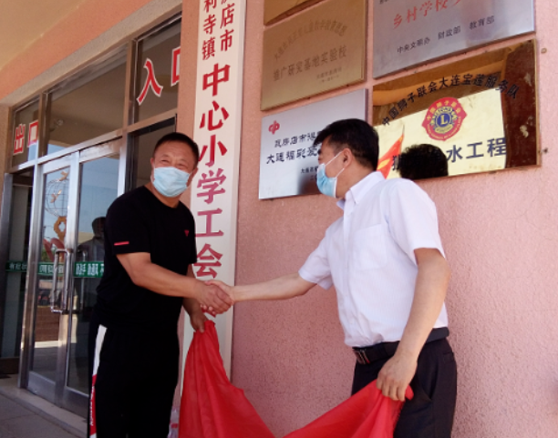 大连市福彩中心主任王廷剑和得利寺镇副镇长卫广东为“大连福彩爱心小学”揭匾