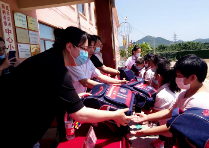 为得利寺镇中心小学的贫困学生发放书包等学习生活用品
