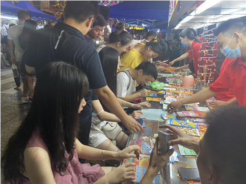 福彩刮刮乐夜市摊位前人们驻足购彩