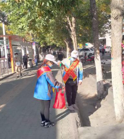 文明劝导员在捡拾路人随手丢弃的垃圾