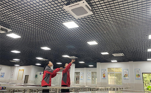 9年级三班的同学陈佳利、於芯如站在空调底下