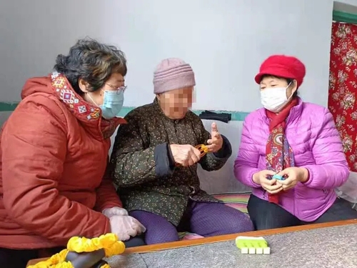 志愿者入户帮助老人进行康复训练